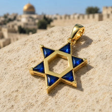 Gold and blue Star of David pendant on a stone surface with a blurred background