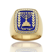 Gold ring with blue emblem featuring a menorah and text on a white background