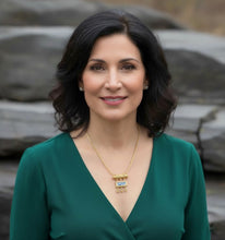 Woman wearing a green dress with a blurred natural background
