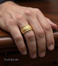 Gold ring on a hand with 'Yoels Jewelry' branding