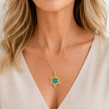 A close-up of a woman wearing a delicate gold chain necklace with a Star of David pendant featuring a vibrant turquoise blue center.