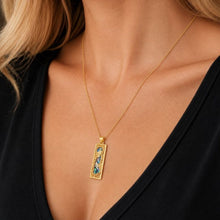 A woman wearing 14k gold Roman Glass Silver Mezuzah Pendant
