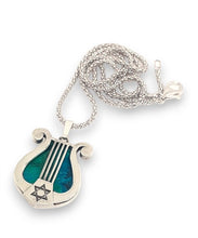A 925 sterling silver harp pendant featuring a green eilat stone in the center, with star of david pendant on the side.
