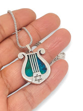 A 925 sterling silver harp pendant featuring a green eilat stone in the center, with star of david pendant on the side.