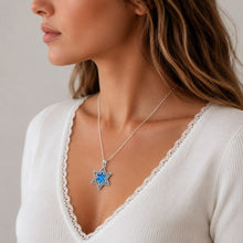 Woman wearing a necklace with a blue pendant