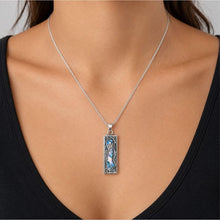 A woman wearing a silver Roman Glass Silver Mezuzah Pendant