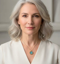 Woman wearing a necklace with a star-shaped pendant against a neutral background