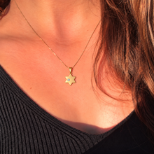 Woman wearing a delicate 1.1 cm gold Star of David pendant with lab-grown diamond