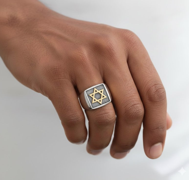 Hand wearing a ring with a Star of David design on a white background