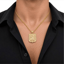 Man wearing a gold Lion of Judah necklace with a black open-collar shirt