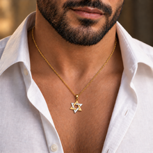 A close-up of a man wearing a gold chain necklace with a Star of David pendant, featuring gold and silver inlay details, styled with an open white linen shirt.