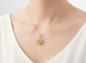 Gold necklace with a star-shaped pendant on a mannequin