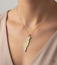 Gold necklace with a unique pendant on a neutral background