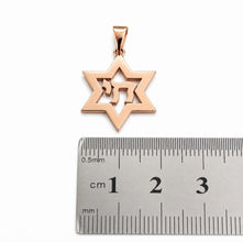 Rose gold Star of David pendant with a ruler for scale on a white background