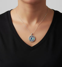 Necklace with a Star of David pendant on a person wearing a black shirt.