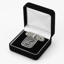 Silver necklace with a menorah design in an open black velvet box on a white background