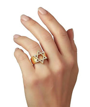 Hand wearing a ring with a star of David design on a white background