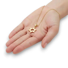 Gold necklace with a star pendant on a hand against a white background