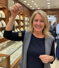 Woman holding a gold necklace in an jewelry store
