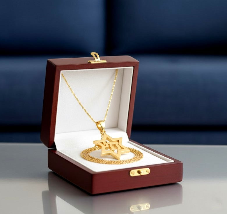 Gold necklace with a star pendant in an open jewelry box on a reflective surface with a blue gradient background.