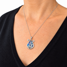 women is wearing roman glass silver harp pendant 
