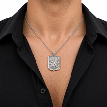 Man wearing a silver Lion of Judah necklace with a black open-collar shirt