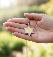 Hand holding a star-shaped pendant with a blurred green background