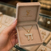 Gold necklace with a pendant in a 'Yoels Jewelry' box