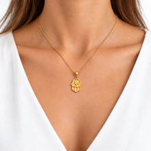 Woman wearing a gold Hamsa pendant with diamond Star of David.