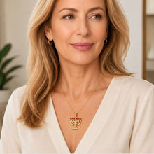 Woman wearing 14K gold menorah necklace with ruby stones