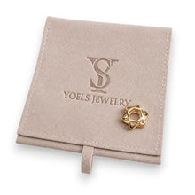 Gold star-shaped earring on a beige Yoels Jewelry box