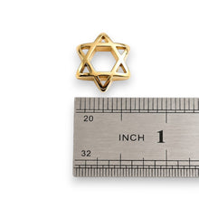 Gold Star of David pendant next to a ruler for scale on a white background