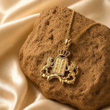 14k gold Ten Commandments pendant with lions and diamond frame resting on brown stone with silk background luxury Jewish jewelry
