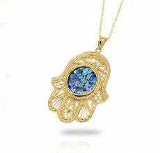 Gold pendant with blue gemstone on a white background
