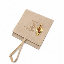 A gold fish-shaped pendant with a red textured body, displayed on a beige suede jewelry pouch with the brand name 'Yoels Jewelry' embossed on it, set against a plain white background.