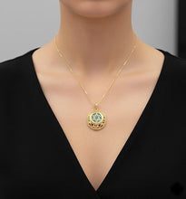 Gold necklace with a star pendant on a mannequin wearing a black top.