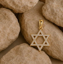 Gold Star of David pendant with diamonds on a stone background