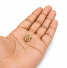 Gold star-shaped object held in a hand on a white background