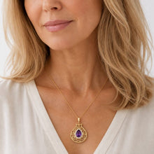 Women is wearing 14K yellow gold pomegranate pendant with amethyst