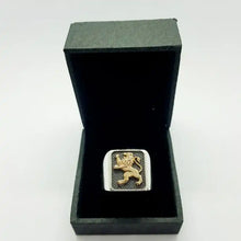 A 925 sterling silver ring with a 9k gold Lion of Judah design on top.