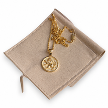 gold lion of Judah pendant on palm displayed on jewelry pouch 