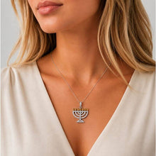 gold  Menorah pendant worn by a person