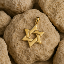 Gold Star of David pendant on a textured stone surface