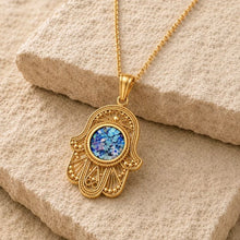 roman glass filigree hamsa pendant made in Israel  on rock 