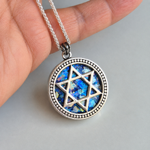 A silver-toned round pendant necklace with roman glass iridescent inlay 