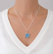 Star of David necklace with blue center on a white sweater