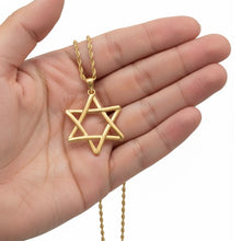 Gold Star of David necklace held in a hand on a white background 