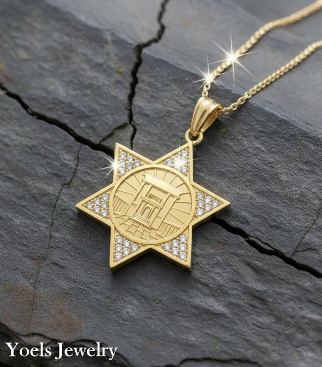 Gold star-shaped pendant necklace on a dark stone surface with 'Yoels Jewelry' branding.