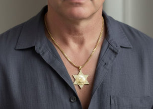 Man wearing a gold necklace with a Star of David pendant.