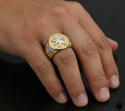 Gold ring with a lion emblem on a hand against a dark background